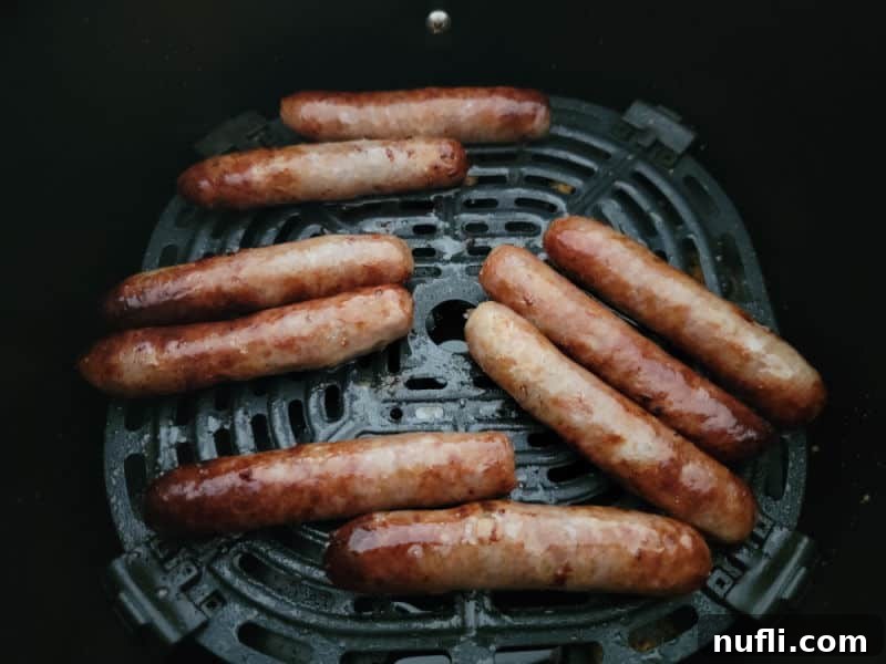 Crispy Air Fryer Sausages 5 A basket full of perfectly air-fried sausage links, golden brown and glistening, ready to be taken out and served.