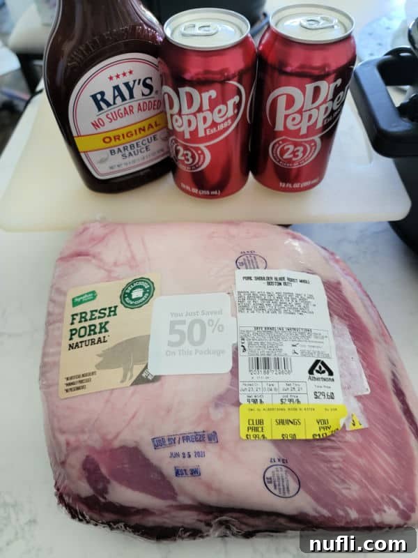 BBQ sauce, Dr Pepper cans, and packaged pork but on a white counter near a slow cooker