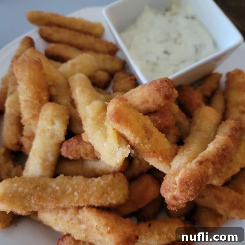 a plate filled with air fried fish sticks and dipping sauce