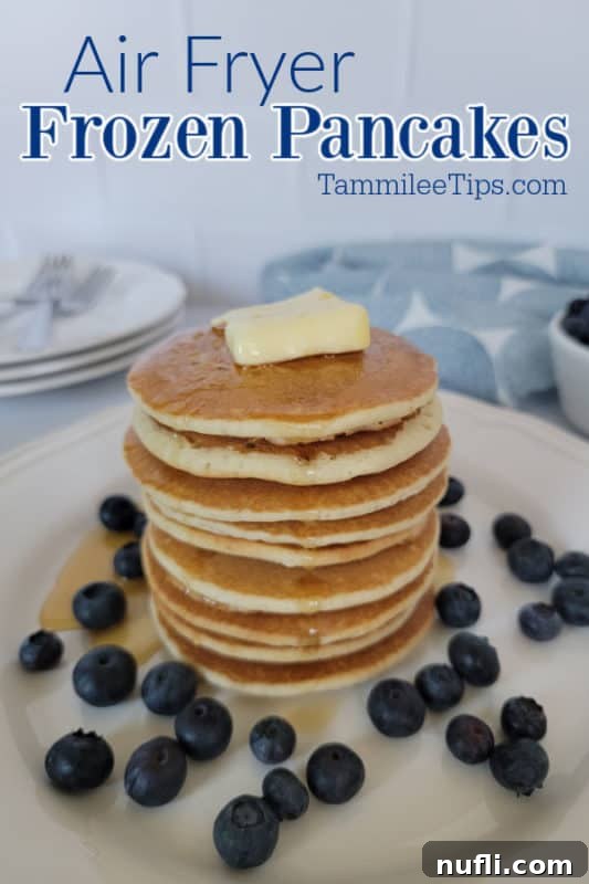 Air Fryer frozen pancakes over a stack of pancakes with butter and blueberries around it. 
