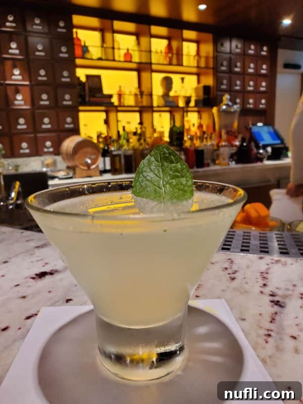 Alchemy Bar's Revved-Up Mojito Martini Elixir 3 Carnival Revved Up Mojito Martini in a stemless martini glass at the Alchemy Bar