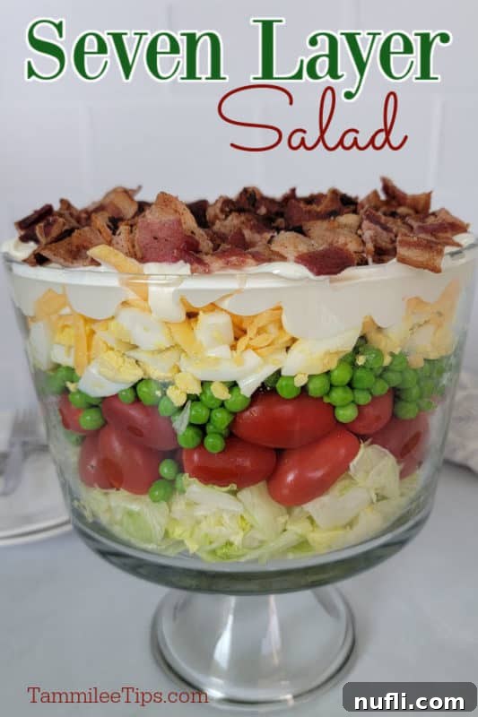 Seven Layer Salad text written over a trifle dish with 7 layer salad on a white counter. 