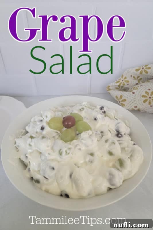 A refreshing grape salad served in a elegant white bowl, garnished with fresh grapes and a cloth napkin on the side.