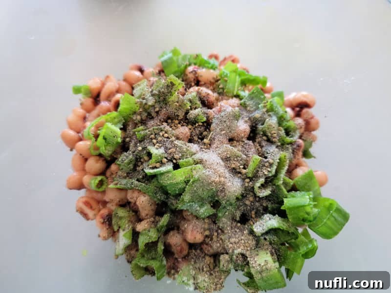 Zesty Black Eyed Pea Medley 4 black eyed peas, green onions, and seasoning in a bowl before mixing