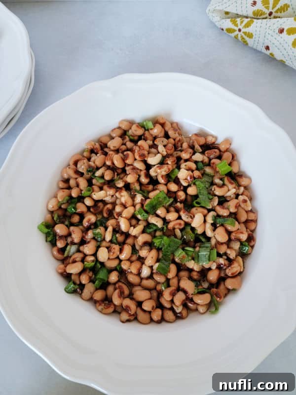 Zesty Black Eyed Pea Medley 5 Black eyed pea salad in a white bowl with plates near it