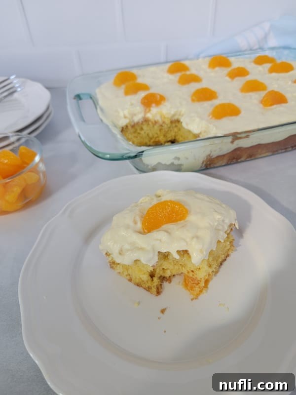 square of Pig Pickin Cake on a white plate next to a baking dish of the cake