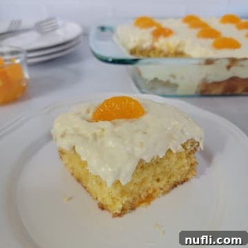 Square of Pig Pickin Cake on a white plate in front of the baking dish and a stack of plates