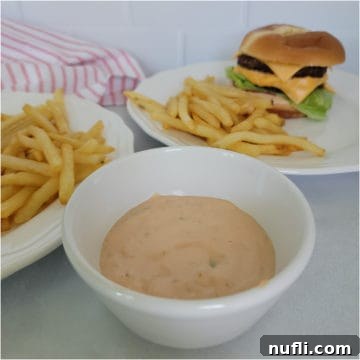 White bowl filled with In n Out Sauce next to a burger and fries