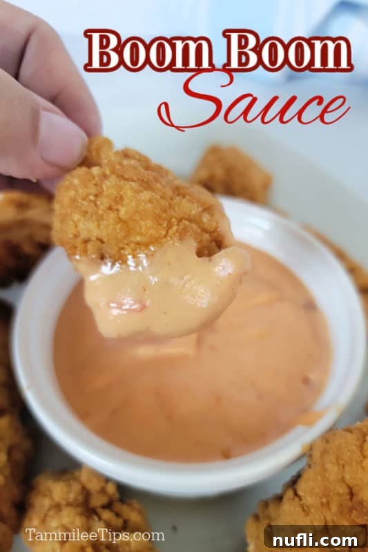 Boom Boom sauce over a Chicken nugget dipping into Boom Boom sauce in a white bowl 