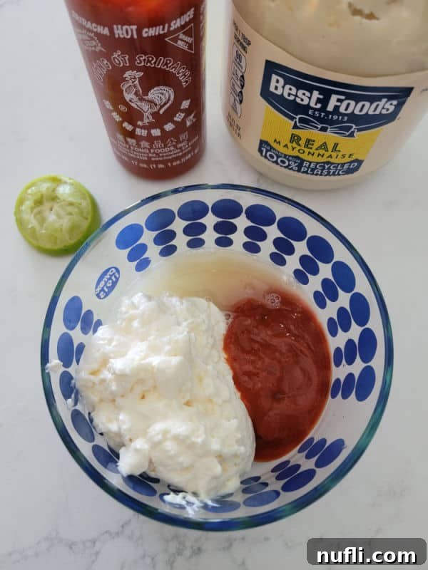 Homemade Japanese Spicy Mayo 4 squeezed lime, bottle of sriracha, and bottle of best foods mayo behind a glass bowl with mayo, sriracha and lime juice in it.