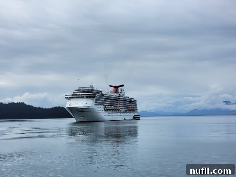 Carnival Cruise ship with clouds and mountains nearby