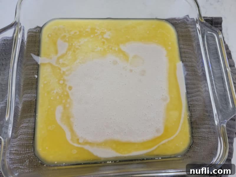 Bisquick poured into melted butter in a glass baking dish