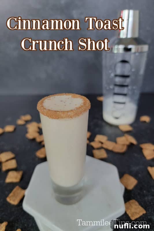 Sweet Cinnamon Crunch Shooter 2 Cinnamon Toast Crunch Shot above a shot glass sitting on two marble coasters. Cocktail shaker in the background with cinnamon toast crunch cereal spread around it