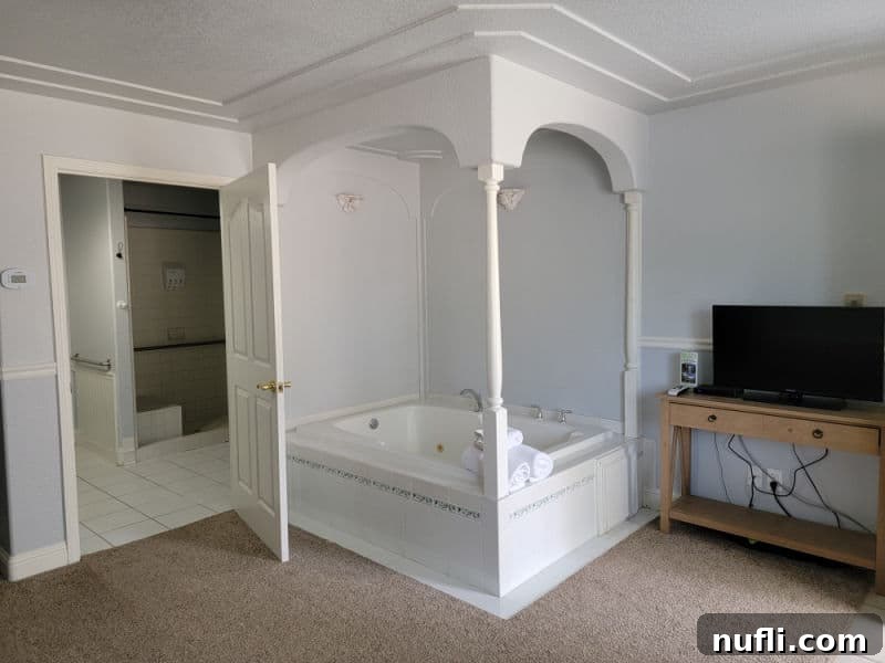 Hounds Tooth Inn in Oakhurst California Closed 4 jetted tub tucked in the corner of the room with a flat screen tv on the top of a desk, inviting relaxation