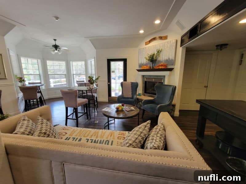 Hounds Tooth Inn in Oakhurst California Closed 6 lobby area with couch, tables and chairs, large painting and windows, showcasing the inviting common space