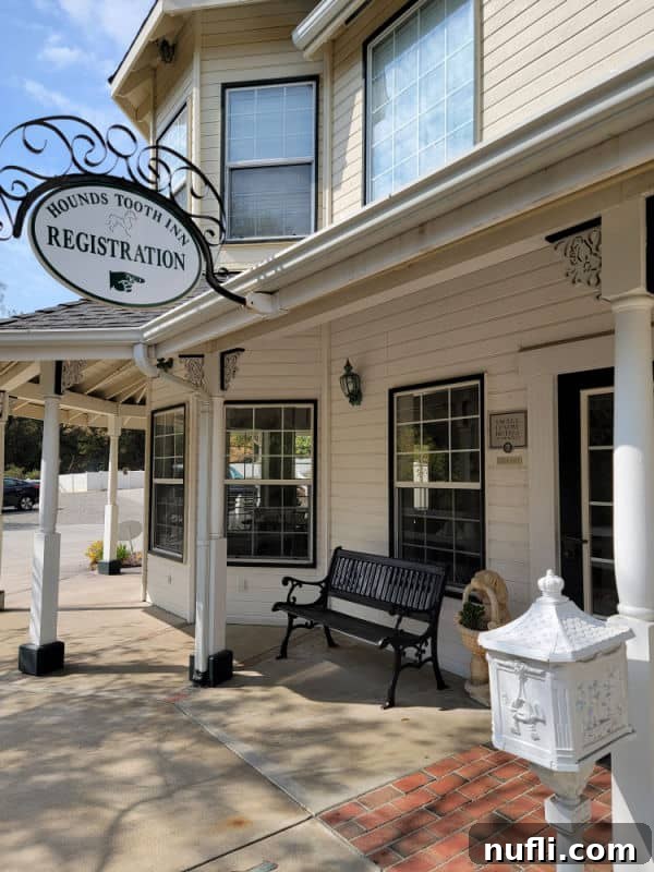 Hounds Tooth Inn in Oakhurst California Closed 7 Hounds tooth inn registration sign with a hand pointing towards the door on a cream colored building, indicating the welcoming entrance