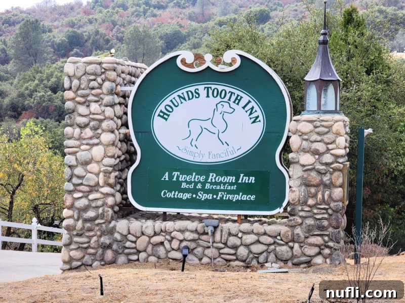 Hounds Tooth Inn in Oakhurst California Closed 9 Hounds Tooth Inn sign with simply fanciful and a dog on it surrounded by rock, a charming landmark