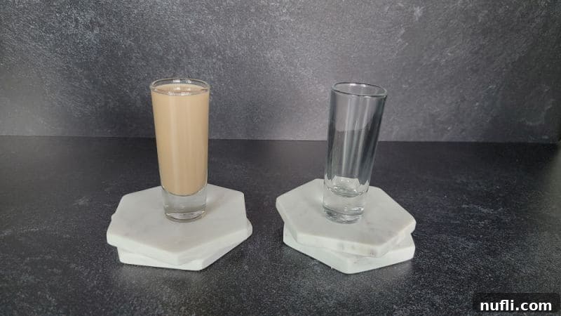 Cement mixer shot in a glass next to an empty glass on coasters