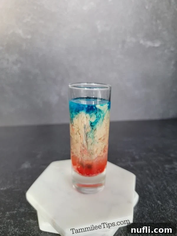 Alien Brain Hemorrhage Shot How To 7 blue liquid floating on cream and red liquid in a shot glass on two coasters