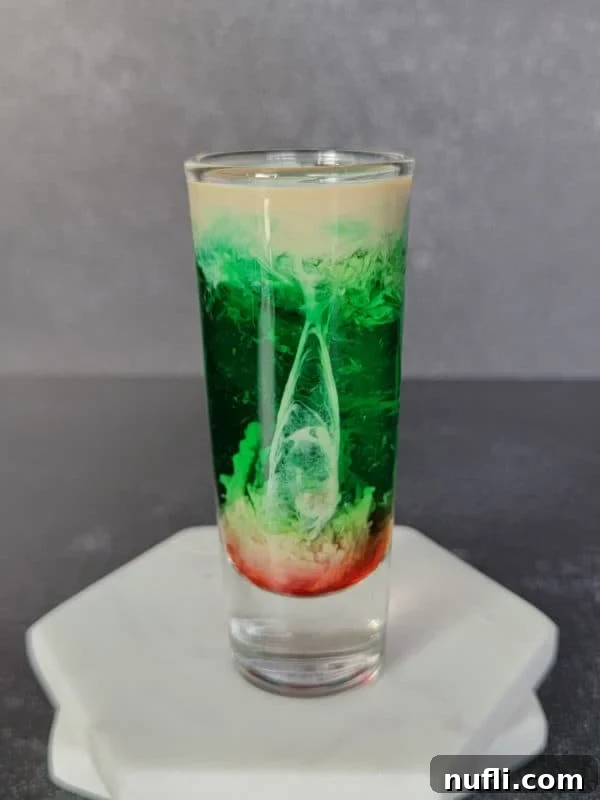layered cream, green and red shot on two coasters