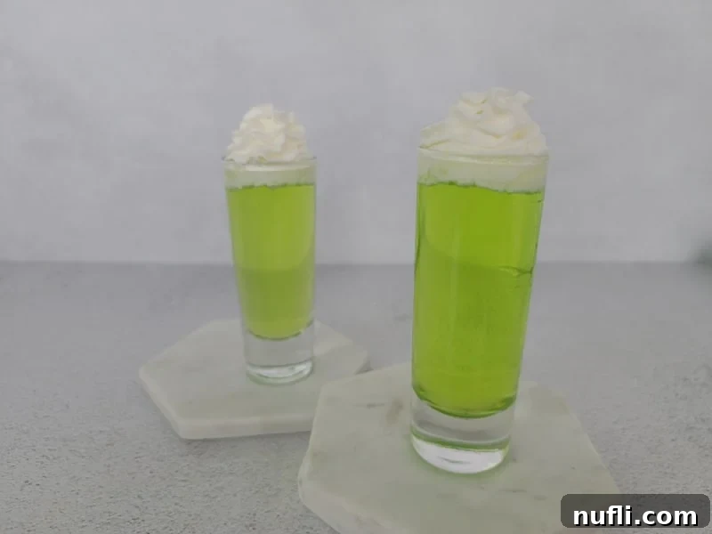 Easy Scooby Snack Shot Recipe 7 2 Bright Green Scooby Snack Shots in clear shot glasses with whipped cream garnish