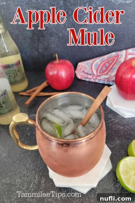 Apple Cider Mule Cocktail 2 Apple cider mule over a copper mug, apples, cinnamon sticks, lime wheels, and ginger beer