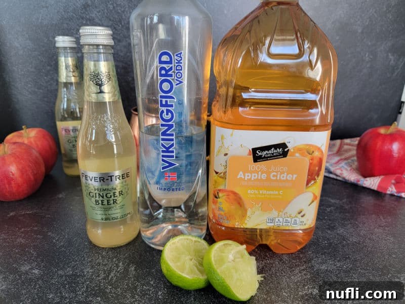 Apple Cider Mule Cocktail 3 bottles of ginger beer, vodka, apple cider, lime wheels, and apples