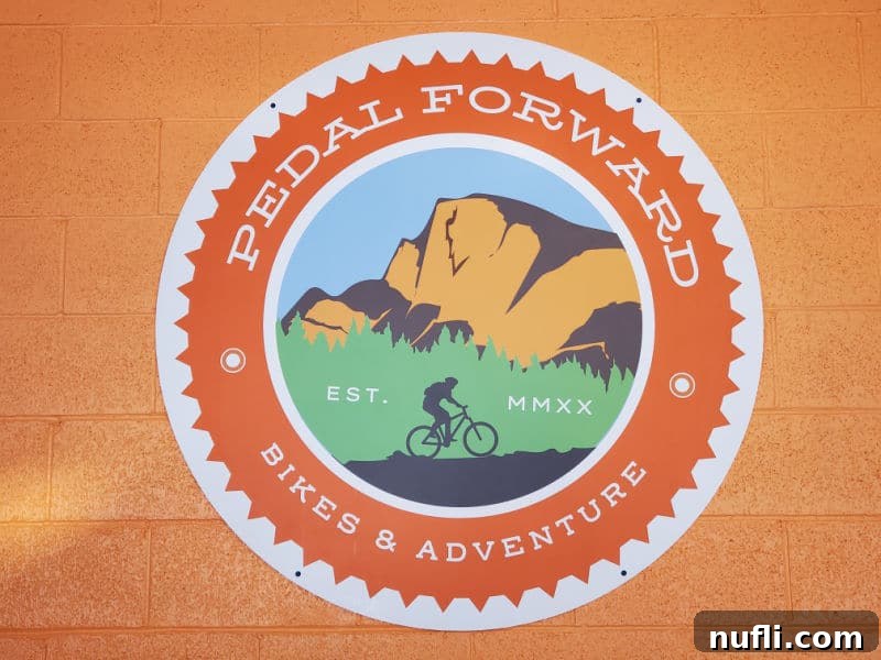 Pedal Forward Bike & Adventure sign with a mountain and figure on a bike