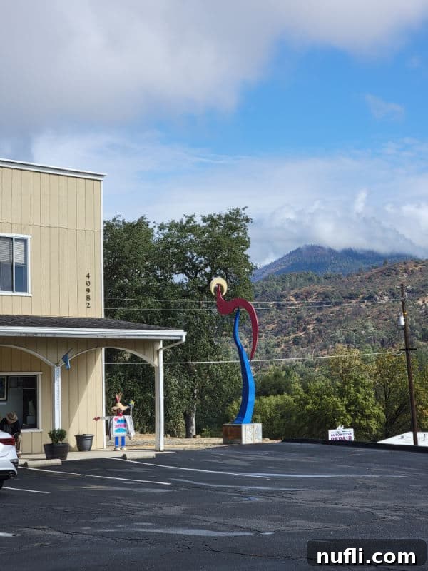 Art sculpture next to a brown building with mountains in the background