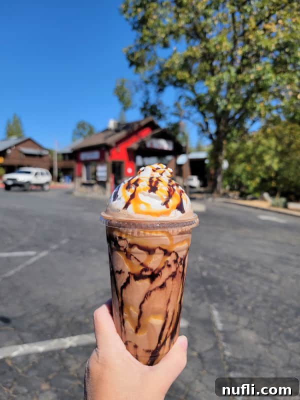 Unlocking North Fork California 9 Caramel and chocolate frozen coffee drink being held up, a refreshing treat.