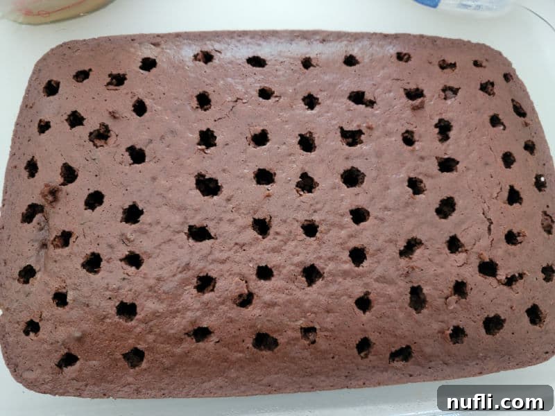 Chocolate cake with holes poked in it for Butterfinger Poke Cake