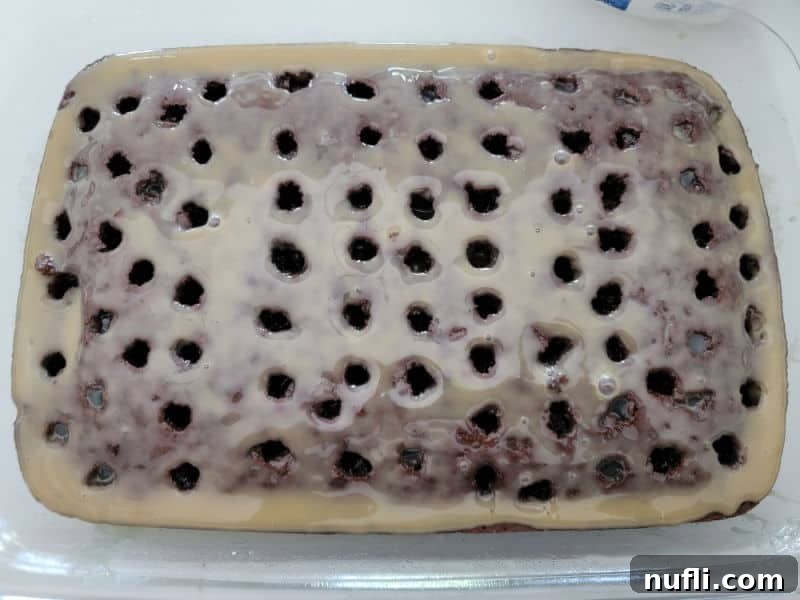 caramel sweetened condensed milk over the top of a chocolate cake with holes poked in it for Butterfinger Cake