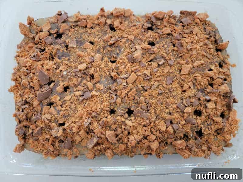 Crushed Butterfinger candy over a poke cake