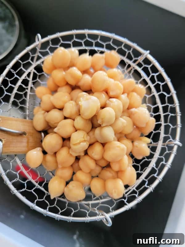 Chickpeas in a spider strainer over a sink