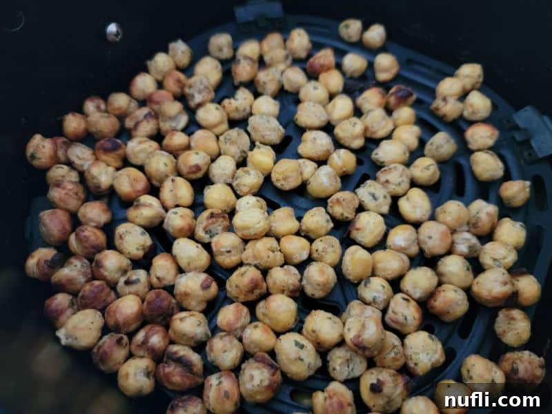 Air fried chickpeas in the air fryer basket, perfectly crispy