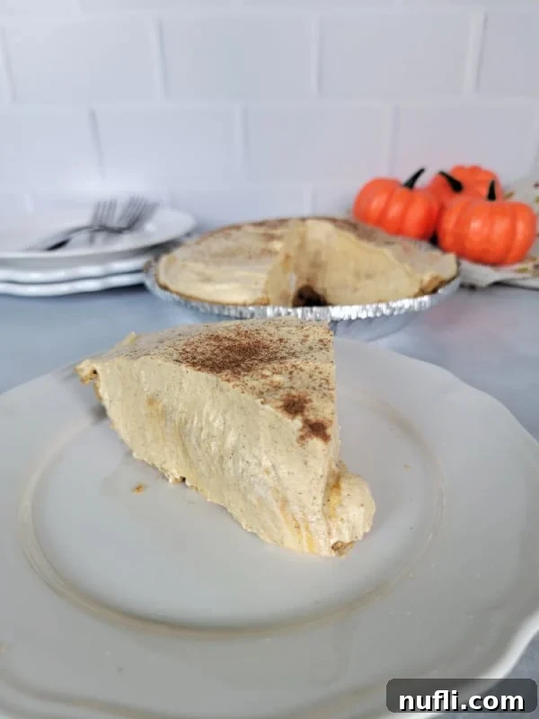 Slice of no bake pumpkin pie on a white plate with the pie dish in the background