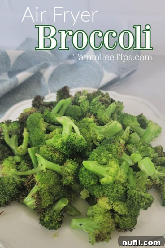 Air fryer broccoli over a white plate with air fried broccoli next to a cloth napkin