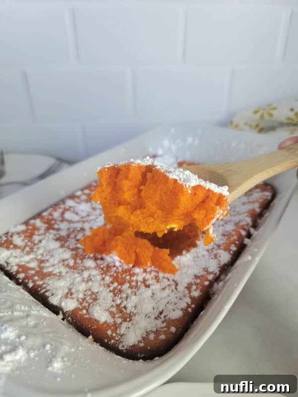 Easy Fluffy Carrot Soufflé 9 A serving of carrot soufflé on a wooden spoon, taken directly from a casserole dish, highlighting its soft texture