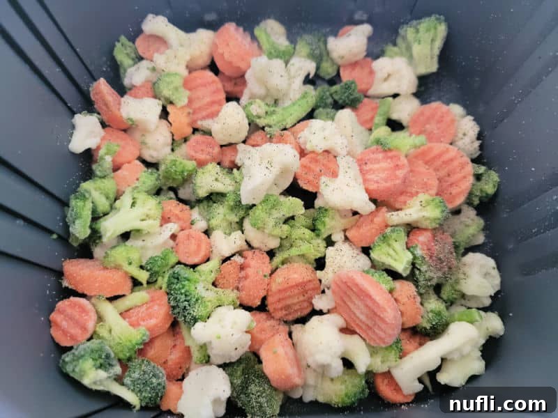 Frozen mixed vegetables ready to be cooked in an air fryer basket.