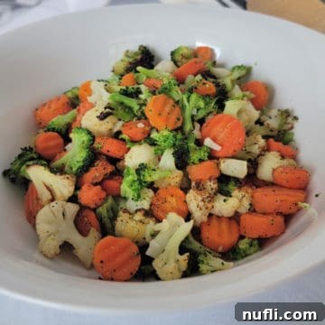Vegetable mix with cauliflower, broccoli and carrots in a white bowl, ready to be served.