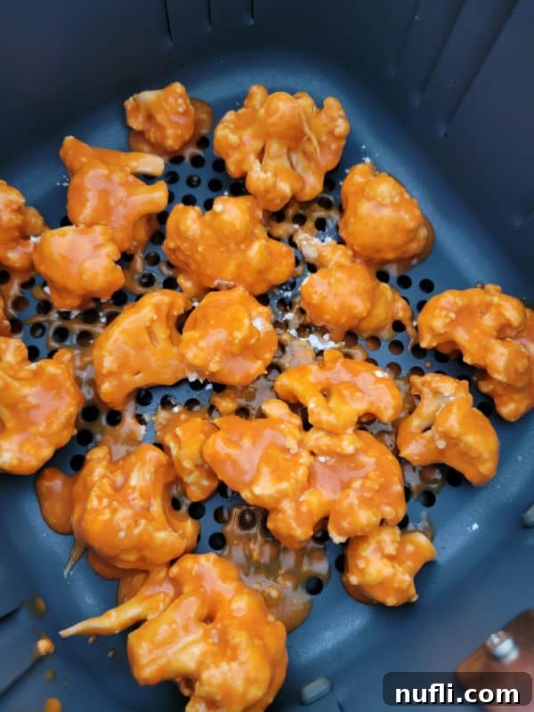 buffalo sauce coated cauliflower in the air fryer basket