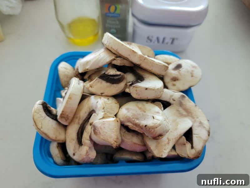 fresh mushrooms in a blue container next to olive oil, pepper, and salt