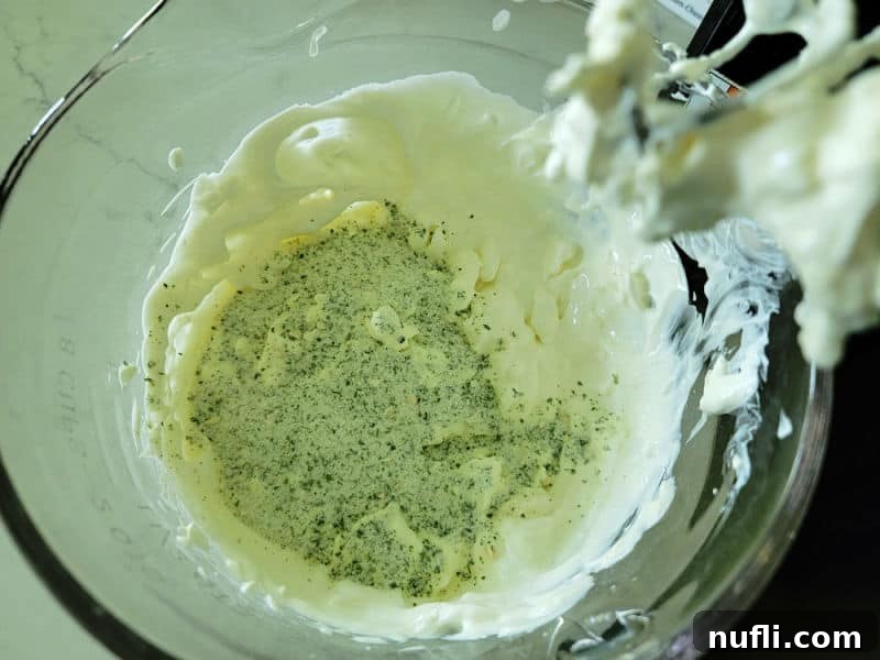 Simple 3-Ingredient Creamy Hidden Valley Ranch Dip 5 Dry ranch seasoning mix over cream cheese and sour cream mixture in a glass bowl