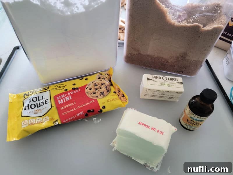 Chocolate chip cheese ball ingredients, powdered sugar, brown sugar, chocolate chips, butter, cream cheese, and vanilla extract on a cutting board