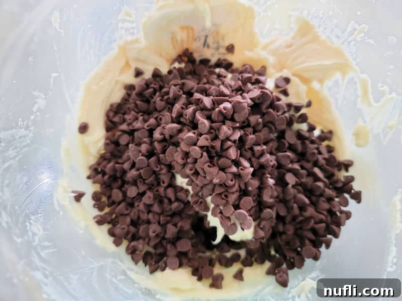 mini chocolate chips on top of cream cheese in a glass bowl for chocolate chip cheese ball