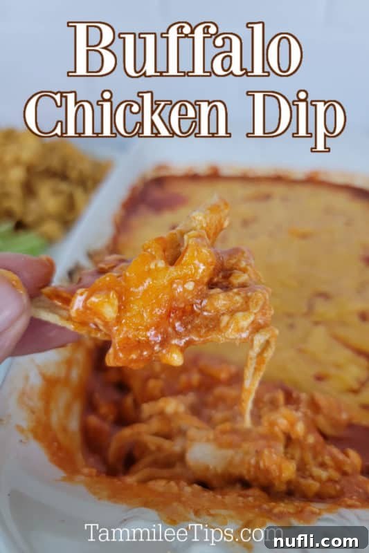 Buffalo Chicken Dip text over a white platter filled with buffalo chicken dip, hand holding a chip covered in dip