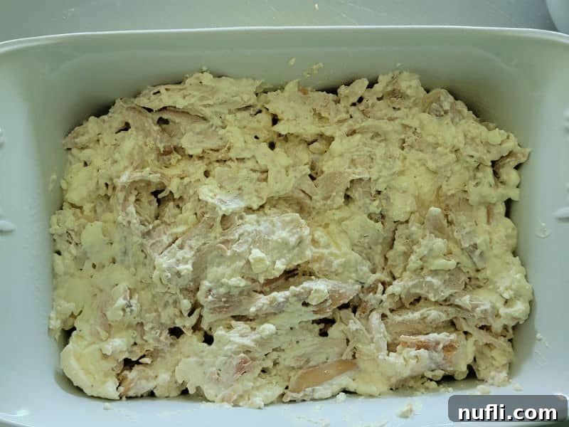 Buffalo chicken mixture spread in a casserole dish