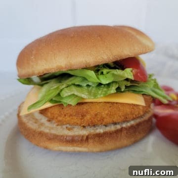 Air fryer chicken patty on a bun with lettuce, cheese and tomato