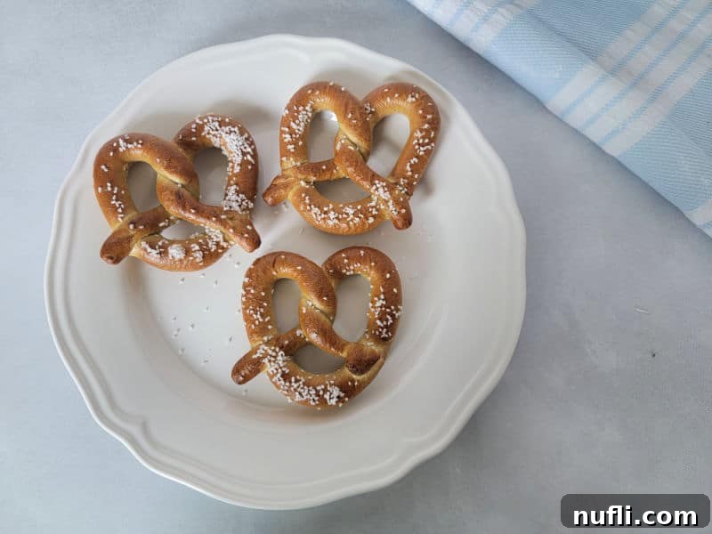 Air fried pretzels on a white plate by a cloth napkin
