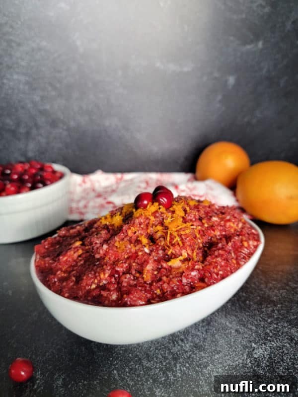 Cranberry Orange Relish garnished with fresh cranberries and orange zest in a white bowl